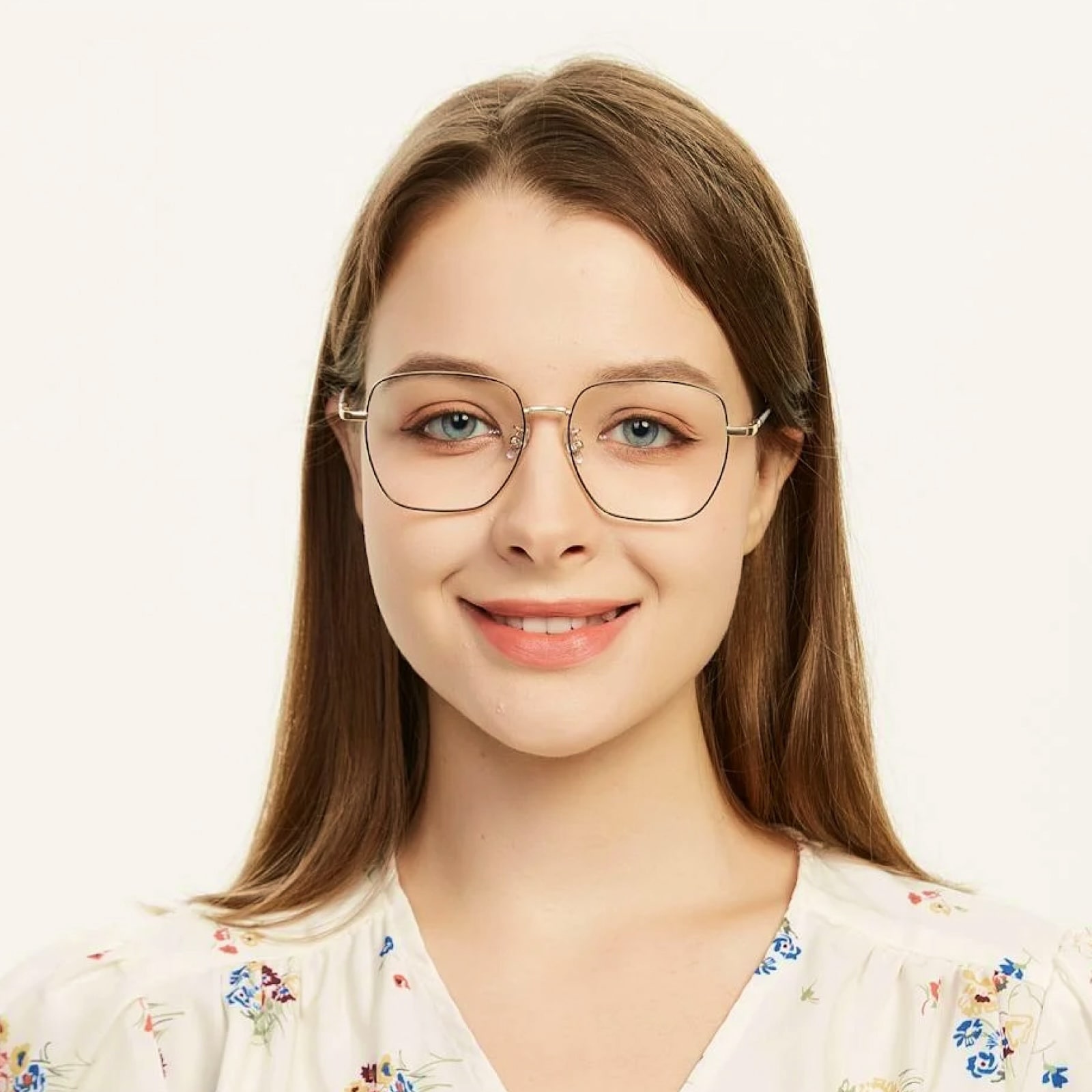 Smiling person with glasses wearing white floral top looking at camera